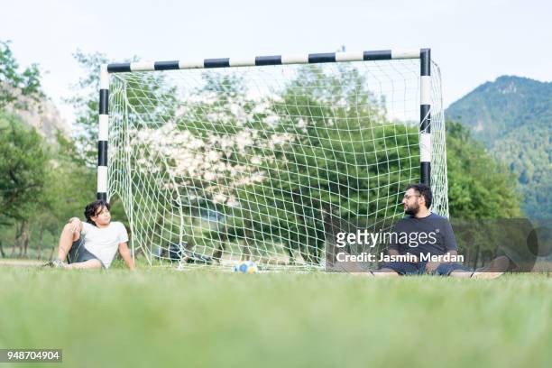 resting on goal after soccer game - kicking tire stock pictures, royalty-free photos & images