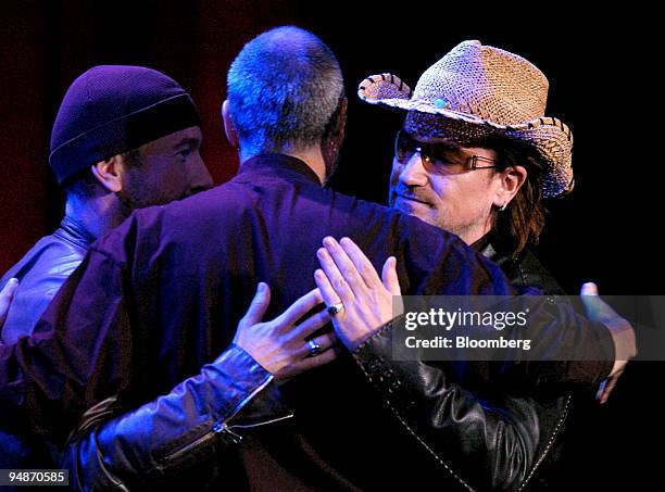 File photo showing U2's Bono, right, and The Edge, left, hugging Steve Jobs, chief executive officer and co-founder of Apple Inc., center, during an...