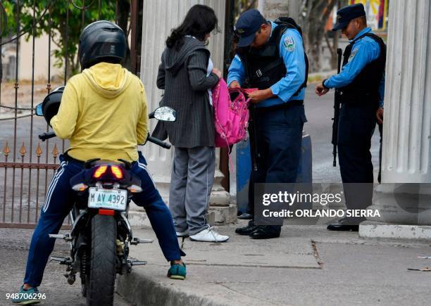 Police officers search students' backpacks at the entrance of the Vicente Caceres Central Institute in Tegucigalpa, on April 18, 2018. - Students are...