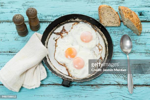 pan of fried eggs and cherry-tomatoes with homemade bread - crepe textile stock-fotos und bilder