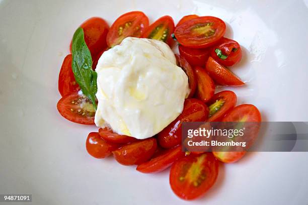 Serving of burrata, a tomato and mozzarella appetizer, is arranged for a photo at Tutto il Giorno, a restaurant located at 6 Bay Street in Sag...