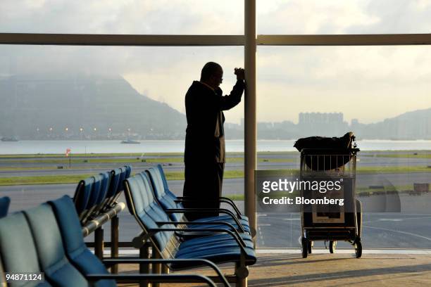 Traveler speaks on his mobile phone prior to boarding his plane at the Chek Lap Kok International Airport in Hong Kong, China, on Friday, July 25,...