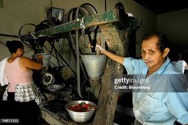 Julio Antonio Beltran works in his mill in Suchitoto, El Salvador, on July 25, 2008. Customers bring rice to be ground into flour or corn to make...