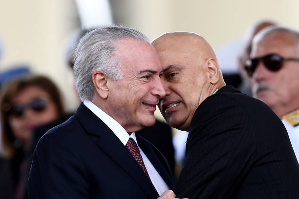 Brazilian President Michel Temer listens to Supreme Court Judge Alexandre de Moraes during a parade on the Brazilian Army commemorative day at the...