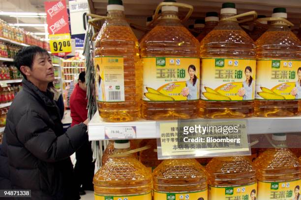 Man shops for corn oil at a supermarket in Shanghai, China, on Monday, March 10, 2008. China's inflation probably surged to another 11-year high in...