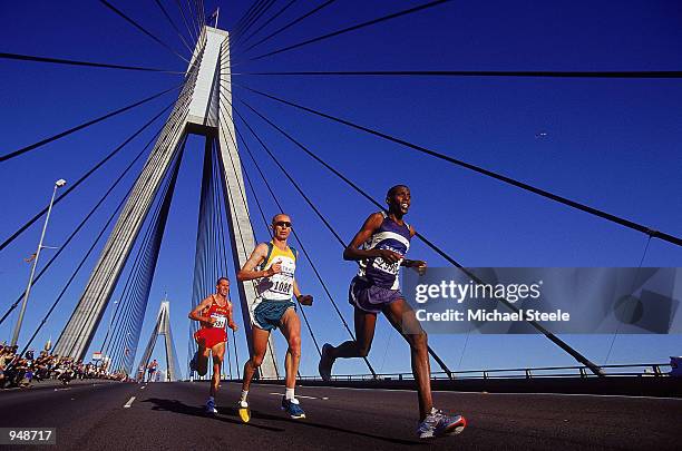 Mattias Ntawulikura of Rwanda leads Steve Moneghetti of Australia across the Anzac Bridge during the Mens Marathon on Day 16 of the Sydney 2000...