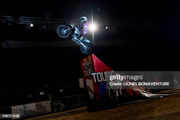 French rider Jey Rouanet performs during a motocross freestyle show in Tours, on April 7, 2018. - Each time, their life is at stake : freestyle...