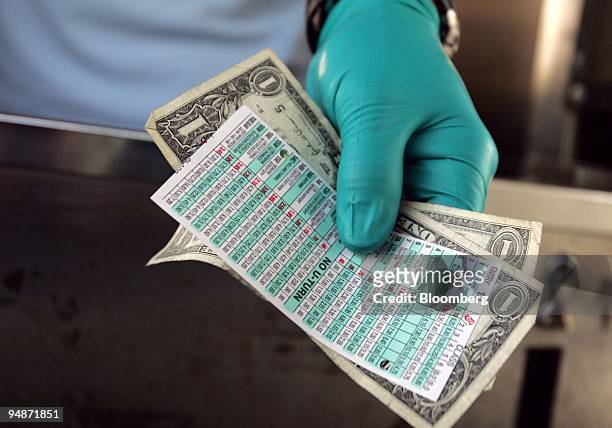 Toll booth clerk holds money and a New Jersey Turnpike toll booth ticket in Newark, New Jersey, Wednesday, October 5, 2005. New Jersey, the state...