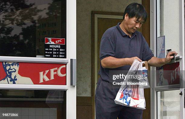 Customer leaves a Kentucky Fried Chicken restaurant with an order in Bloomfield, New Jersey, Wednesday, October 5, 2005. Yum! Brands Inc., operator...