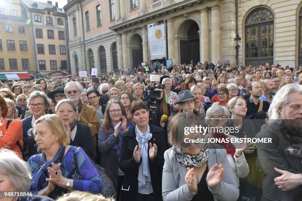 People gather at Stortorget square in Stockholm while the Swedish Academy held its weekly meeting at the Old Stock Exchange building seen in the...