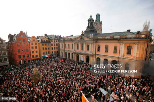 People gather at Stortorget square in Stockholm while the Swedish Academy held its weekly meeting at the Old Stock Exchange building seen in the...