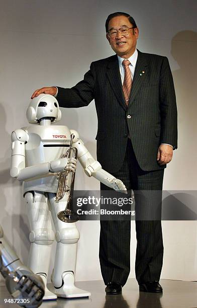 Toyota Motor Corp. President Fujio Cho poses with a "Toyota Partner Robot" during a news conference in Tokyo, Japan Thursday, March 11, 2004.