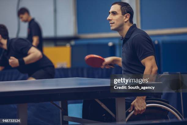 man plezier tijdens het spelen van tafeltennis - wheelchair tennis stockfoto's en -beelden