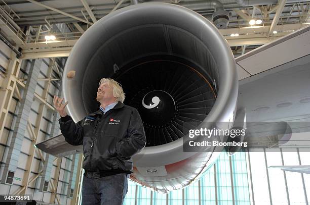 Richard Branson, chairman of Virgin Group, tosses a babassu nut in the air during a news conference at Heathrow International Airport in London,...