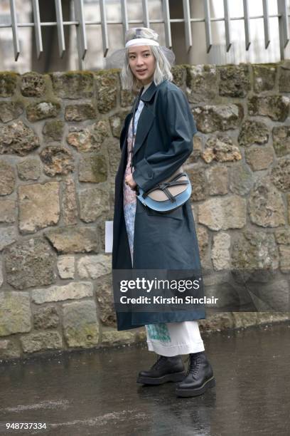 Fashion blogger and model Irene Kim wears a Celine jacket, Chanel hat, Loewe bag and dress day 5 of Paris Womens Fashion Week Spring/Summer 2018, on...