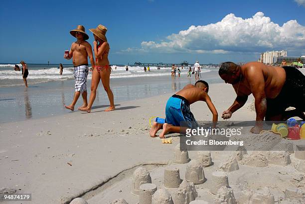 Steven Hendricks, far right, and his son Aaron play in the white sand in Clearwater Beach, Florida, U.S., on Saturday, Sept. 13, 2008. As few as 50...