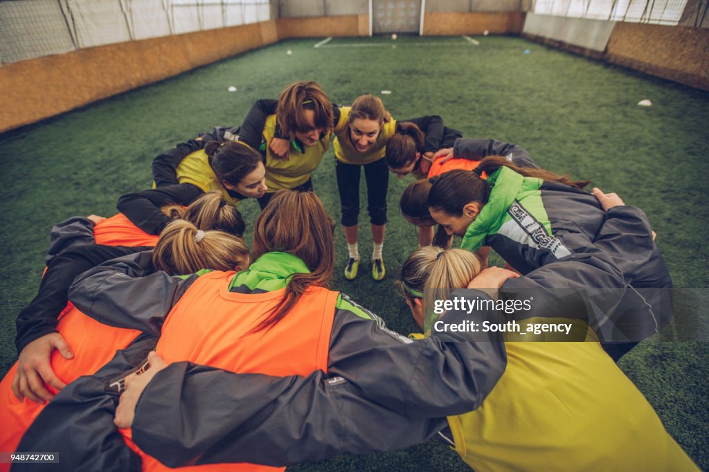 Female soccer team huddling