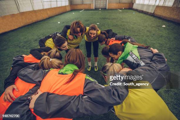 female soccer team huddling - club football stock pictures, royalty-free photos & images