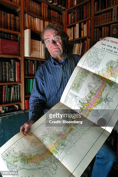Alphonse Chavroche owner of an antiquarian bookshop, poses with a copy of a map showing the location of the original AOC classified wines of the...