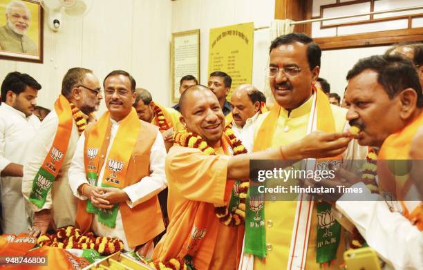 Chief Minister Yogi Adityanath offers sweets to newly elected BJP MLCs, at UP Assembly on April 19, 2018 in Lucknow, India. All 13 candidates,...