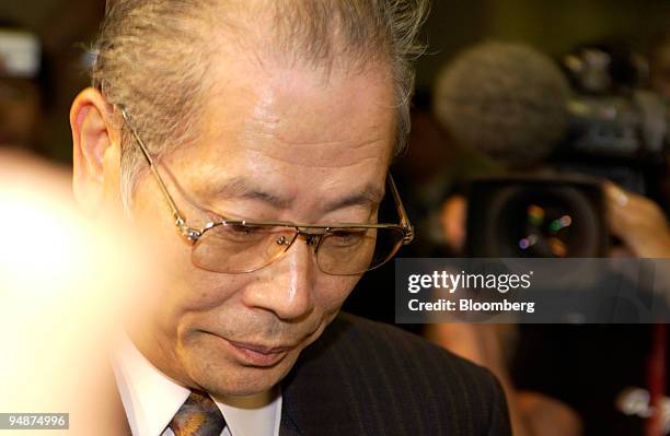 Kunio Takagi, the president of Daiei Inc., enters a press briefing while surrounded by photographers at the Tokyo Stock Exchange on October 15, 2004....