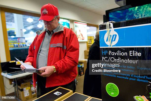 John Hancock looks over paperwork before buying an HP computer inside a Micro Center store Columbus, Ohio, U.S., on Monday, Feb. 18, 2008. Behind...