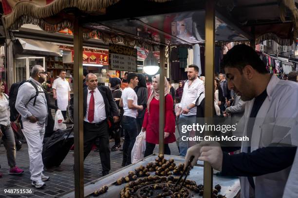 People shop in a market street as a man sells chestnuts on April 19, 2018 in Istanbul, Turkey. Turkish President Recep Tayyip Erdogan on 18 April,...