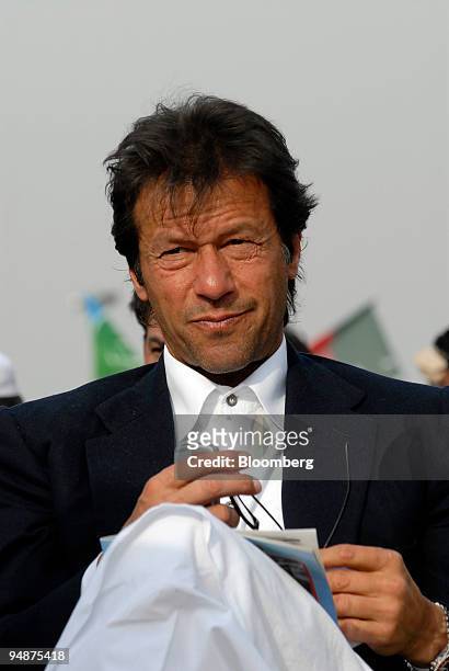 Imran Khan, head of the Tehrik-e-Insaaf party, center, waits to speak to supporters at an All Parties Democratic Movement rally in Lahore, Pakistan,...