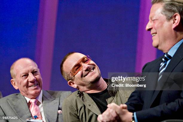 Bono, center, laughs with Al Gore, former U.S. Vice president, right, and E. Neville Isdell, chairman of The Coca-Cola Co., left, during day one of...