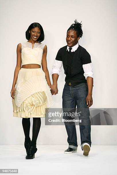 Gavin Douglas, fashion designer, right, acknowledges applause with one of his models at the end of his autumn/winter 2008 fashion show in London,...
