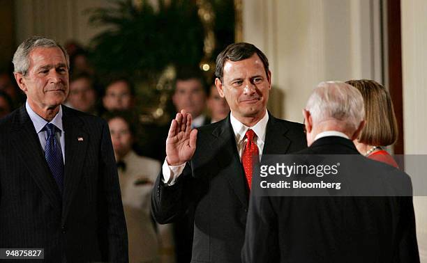 John Roberts holds up his right hand as he is sworn in as the 17th Chief Justice of the U.S. Supreme Court by Supreme Court Justice John Paul...
