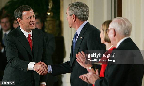 President George W. Bush shakes hands with Chief Justice John Roberts, left, after he was sworn in during a White House ceremony in Washington DC,...