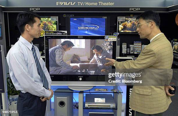 Sales clerk, left, listens to a customer's question about Samsung Electronics PDP flat screen displays at the Samsung Digital Plaza in Ilsan, South...