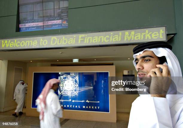 Man talks on a cell phone outside the entrance to the Dubai Financial Market, located at the Dubai World Trade Centre in Dubai, United Arab Emirates,...