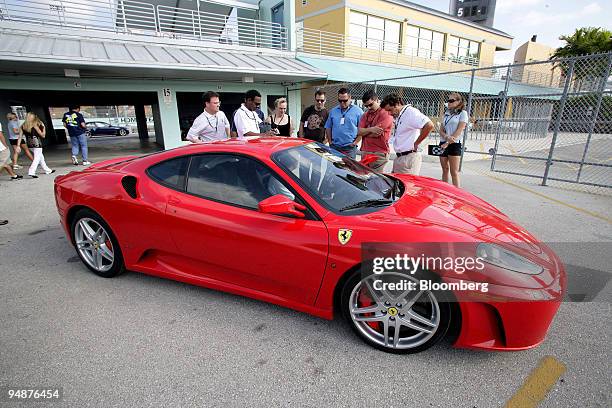 Participants in the Supercar Life driving program gather around a Ferrari 430 at Homestead Miami Speedway in Homestead, Florida, U.S., on Monday,...