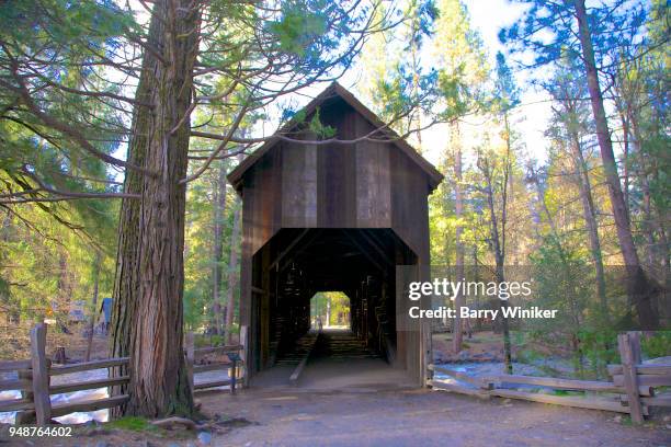 wood covered bridge over the merced river, yosemite np - ponte coberta ponte - fotografias e filmes do acervo