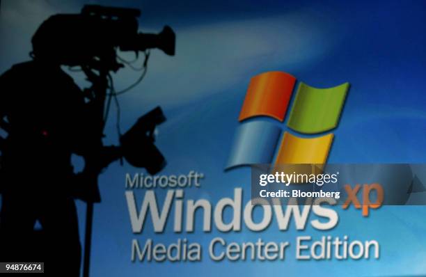 Cameraman is silhouetted as the logo of the Microsoft Windows XP Media Center Edition during its launch at the Shrine Auditorium Tuesday October 12,...