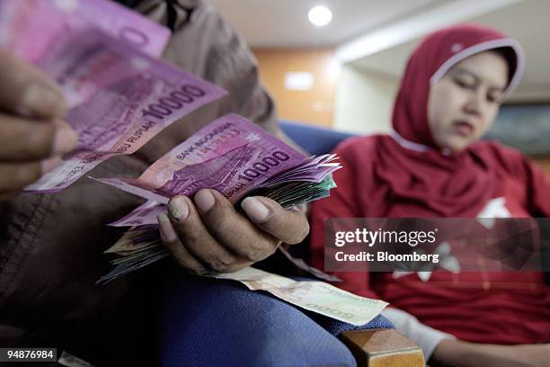 Man counts Indonesian rupiah bills at a money at currency exchange in Jakarta, Indonesia, on Tuesday, Oct. 7, 2008. Indonesia's President Susilo...