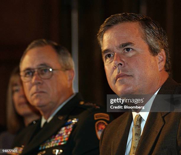 Florida Governor Jeb Bush, right, sits next to General James T. Hill, as he is introduced as the first speaker at the Americas Conference in Coral...