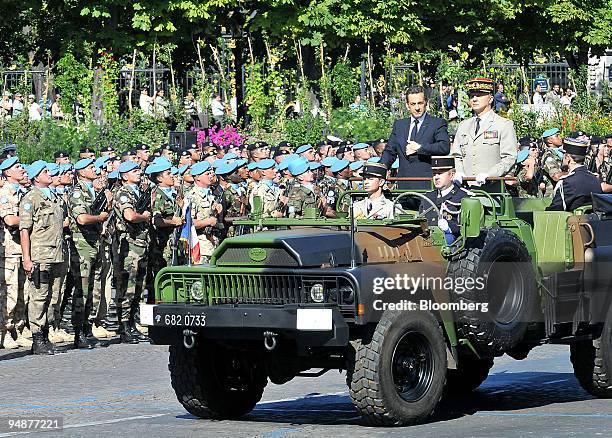 Nicolas Sarkozy, France's president, center standing, with Jean-Louis Georgelin, Chief of the Defense Staff, standing right,inspect members of the...