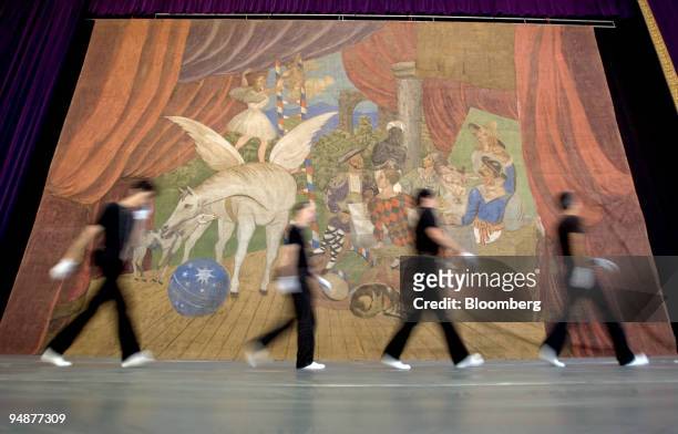 After hanging the masterpiece, workmen walk past Pablo Picasso's stage curtain for the realist ballet "Parade" on display at a shopping center in...