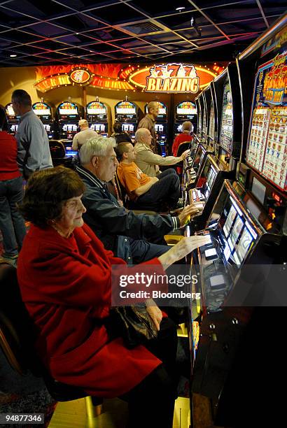 Florence Materna, front, plays the first slot machine gaming available in Pennsylvania at the Mohegan Sun at Pocono Downs Thursday, November 16, 2006...
