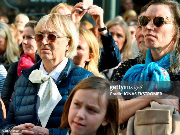 People gather at Stortorget square in Stockholm while the Swedish Academy held its weekly meeting at the Old Stock Exchange building seen in the...