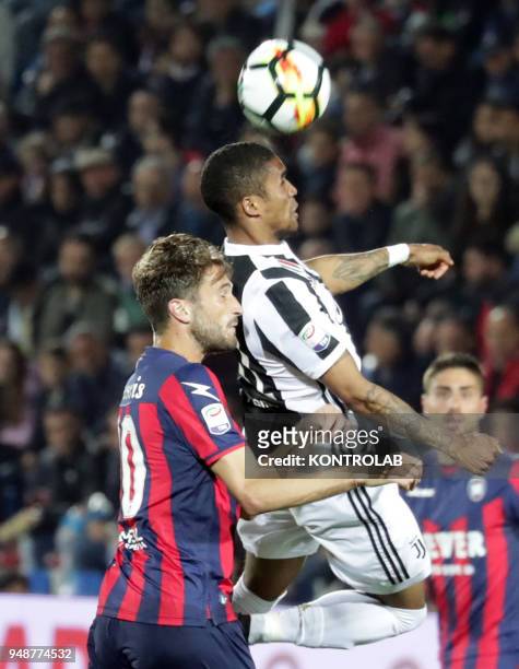 Juventus' Brazilian striker Douglas Costa heads the ball as fighting with Crotone's Italian midfielder Andrea Barberis during the Italian Serie A...
