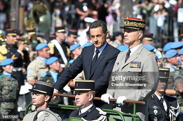Nicolas Sarkozy, France's president, center standing, with Jean-Louis Georgelin, Chief of the Defense Staff, standing right,inspect members of the...