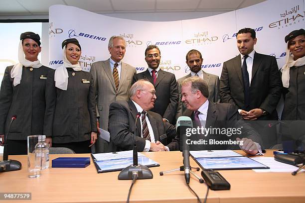 Scott Carson, chief executive officer of Boeing Commercial Airplanes, left foreground, shakes hands with James Hogan, chief executive officer of...