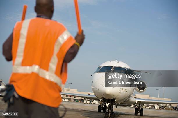 Gregory Pierce guides an Atlantic Southeast Airlines airplane into a gate at Hartsfield-Jackson International Airport in Atlanta, Georgia, U.S., on...