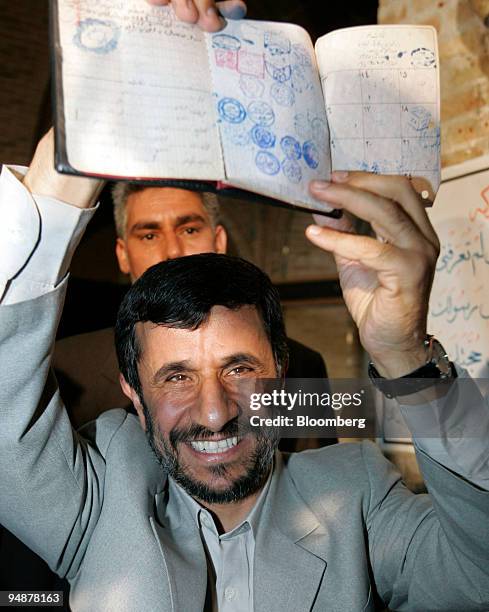 Mahmoud Ahmadinejad, Iran's president, holds up his birth certificate marked with election stamps after casting his vote at a mosque in Tehran, Iran,...