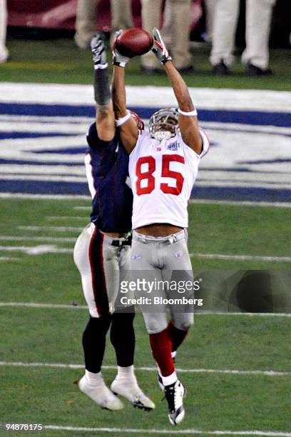 David Tyree of the New York Giants catches a pass for a first down against the New England Patriots in the fourth quarter of Super Bowl 42 at the...