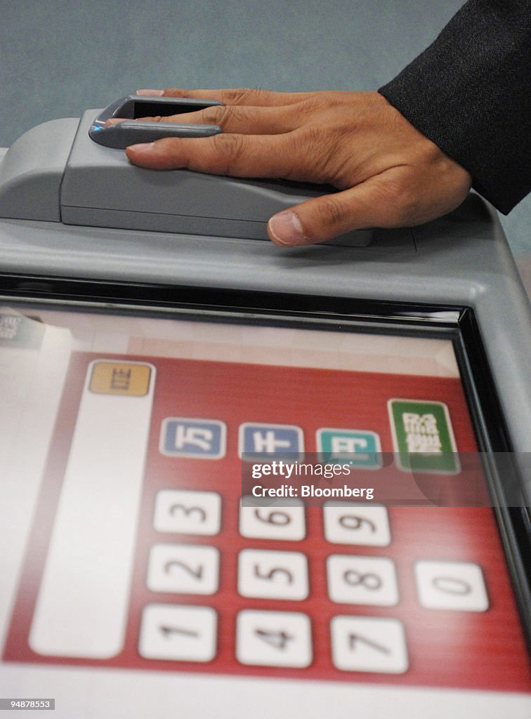 A Hitachi Ltd. employee demonstrates a biometric ATM that sc
